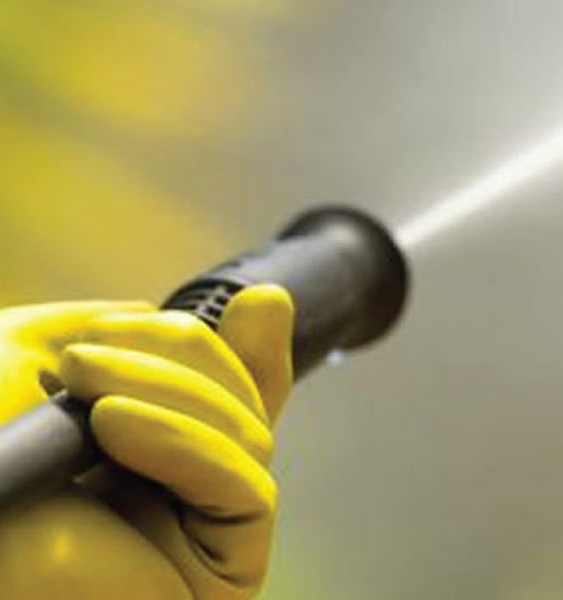 water-blasting-about Blasting water out of a black color pipe with a hand holding it wearing yellow color gloves.